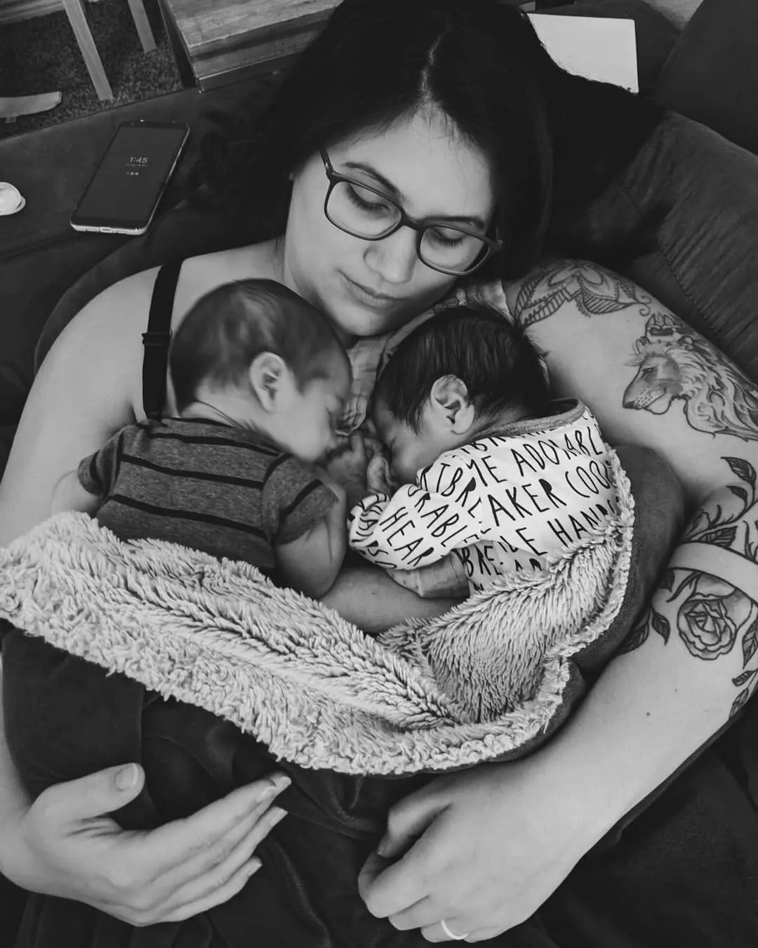 Kayla resting with her newborn twins asleep on her chest